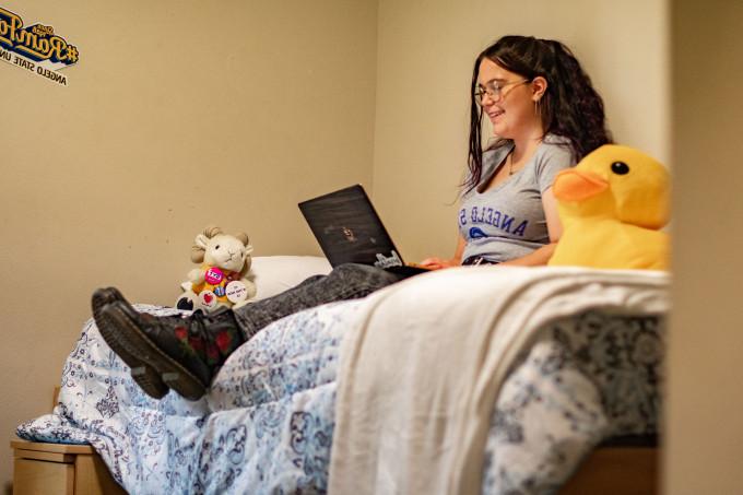 Student studying in her room within Centennial Village.